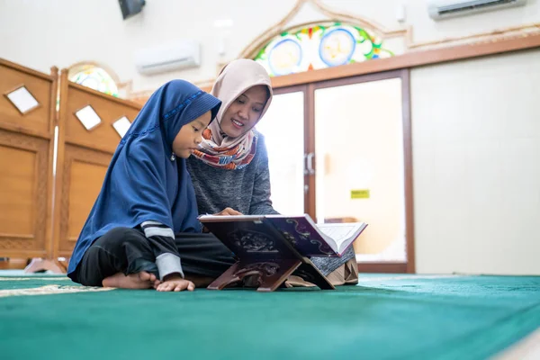 穆斯林妇女，带着孩子，一起阅读quran语 — 图库照片
