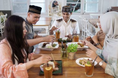 Müslüman bir arkadaş öğle yemeği yiyor.