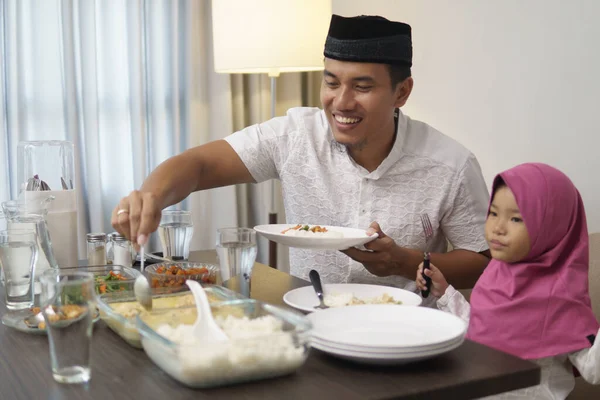 Чоловік снідає вечерю зі своєю донькою і сім'єю — стокове фото