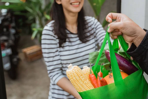 Bezorger is het leveren van sommige boodschappen naar vrouw — Stockfoto