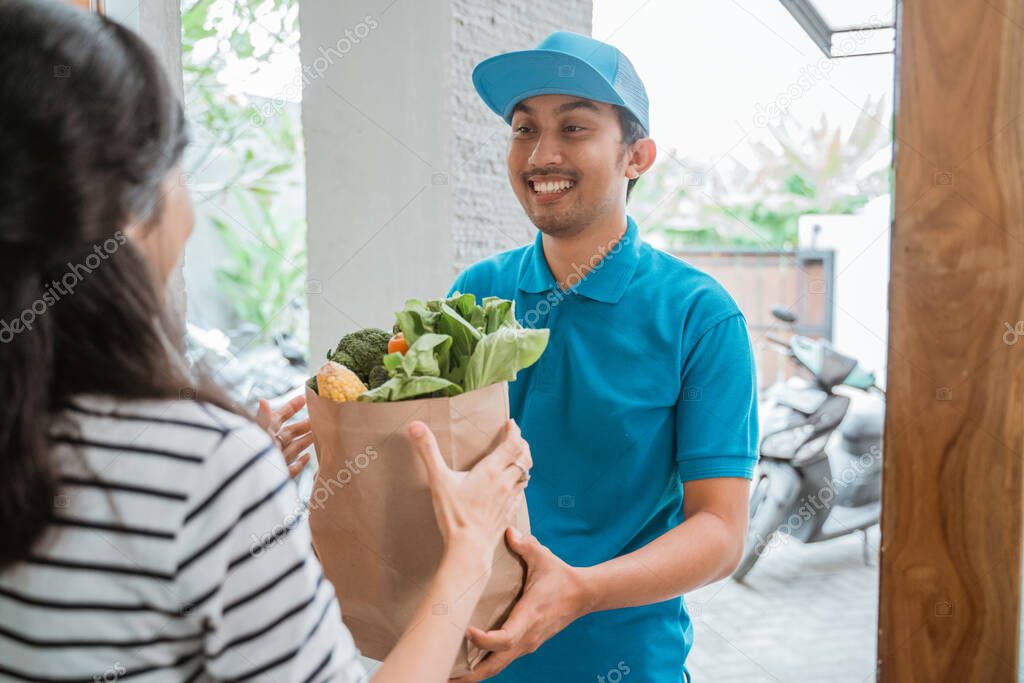 delivery boy is delivering some groceries to woman