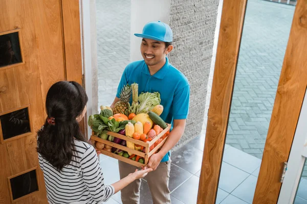 Mujer sonriente recibiendo entrega de comestibles en casa — Foto de Stock