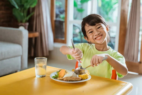 Niño sonriendo a la cámara mientras desayuna sano —  Fotos de Stock