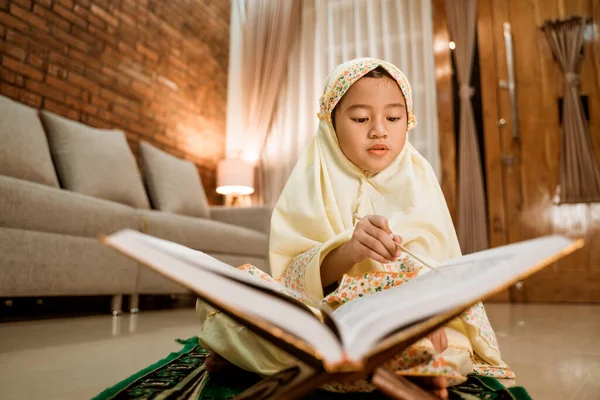 Menina lendo Quran por si mesma em casa — Fotografia de Stock