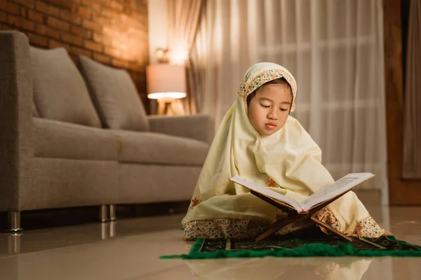 Menina lendo Quran por si mesma em casa — Fotografia de Stock