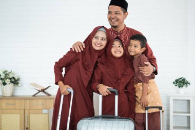 Müdik taşımak için bavulları olan Asyalı Müslüman aile.