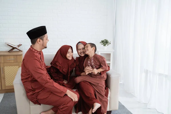 Melayu Muslim keluarga duduk di sofa menikmati liburan — Stok Foto