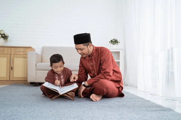 A boy learns the Al-Quran with her father — Stock Photo, Image