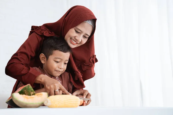 Ibu dan anak memotong buah untuk berbuka puasa — Stok Foto