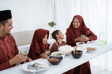 Müslüman aile kahvaltıda yemek için oturur.