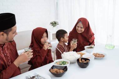 Müslüman aile kahvaltı yaparken tatlı içkinin tadını çıkarıyor.