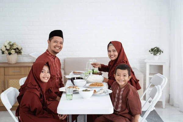 Moslim familie zitten en glimlachen als we naar de camera kijken — Stockfoto