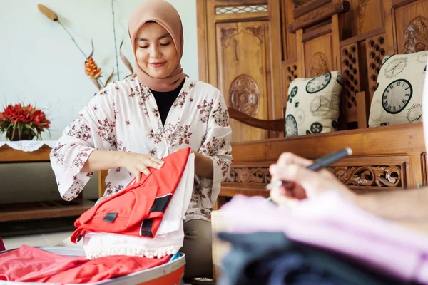 Muslim wanita terselubung kemasan beberapa pakaian — Stok Foto