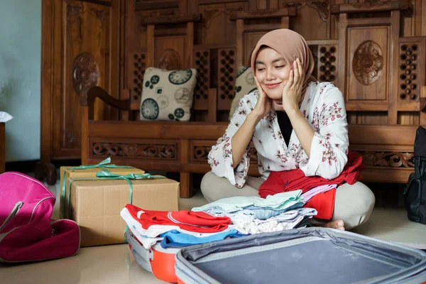 Muszlim fátyolos nő csomagol néhány ruhát — Stock Fotó