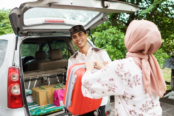 Muslimisches Paar lädt seinen Koffer in den Kofferraum — Stockfoto