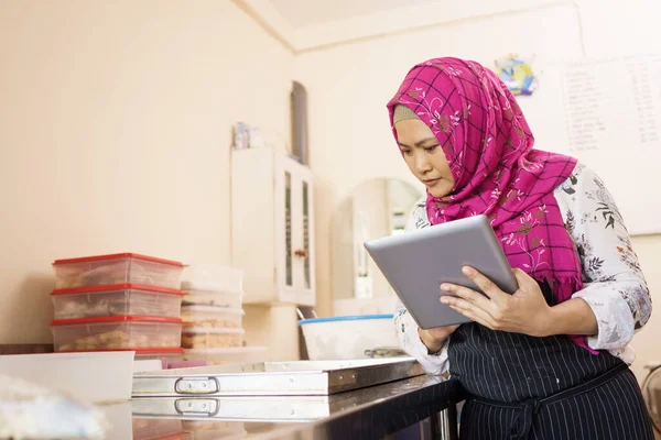 Muslim žena obchodní majitel kontroluje její pečivo — Stock fotografie