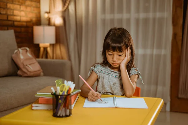 Kid studying by herself in the evening — Stock Photo, Image