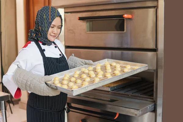 Glad muslimsk kvinna bakar ananas tårta — Stockfoto