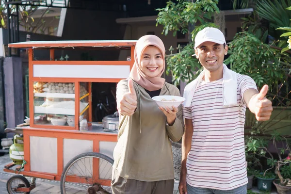 Homem vendendo bakso nos carrinhos com o cliente — Fotografia de Stock