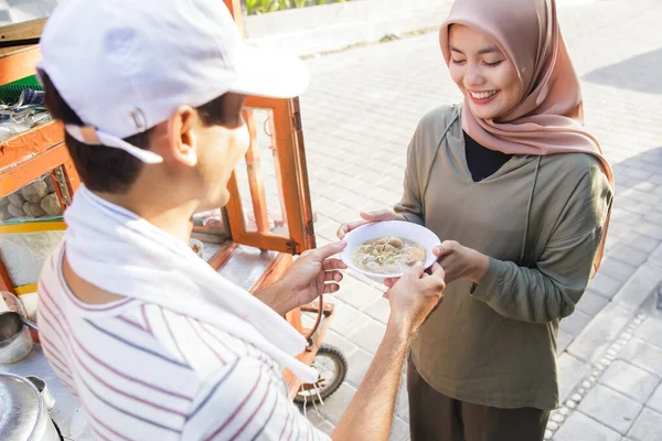 Penjual makanan jalanan menyerahkan mangkuk bakso — Stok Foto