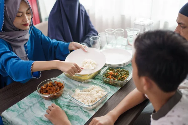 Moeder moslim serveert voedsel voor familie — Stockfoto