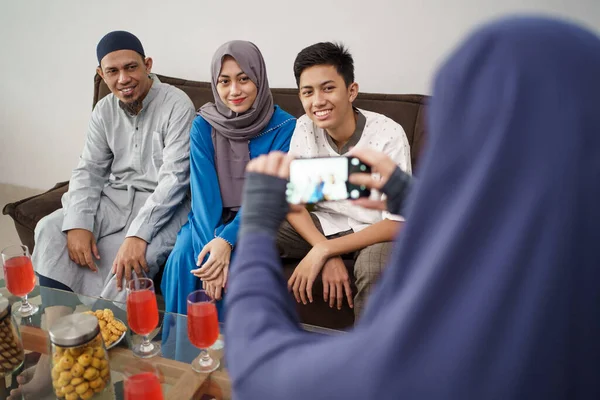 Laki-laki muslim mengambil gambar keluarganya sambil duduk di sofa — Stok Foto