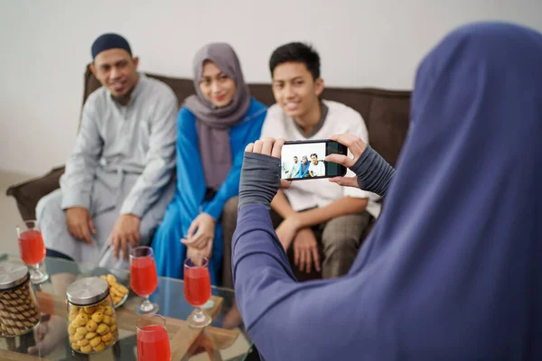 Laki-laki muslim mengambil gambar keluarganya sambil duduk di sofa — Stok Foto