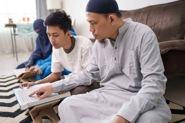 Moslim familie leest koran samen in woonkamer — Stockfoto