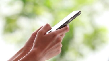 Kadın elleri dışarıda dokunmatik telefon kullanıyor.