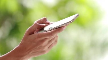 Kadın elleri dışarıda dokunmatik telefon kullanıyor.