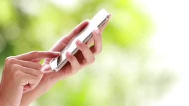 Kadın elleri dışarıda dokunmatik telefon kullanıyor.