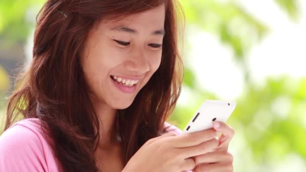 Egy nő, aki érintőképernyős telefont használ a szabadban. összpontosítson a mobiltelefonra — Stock videók