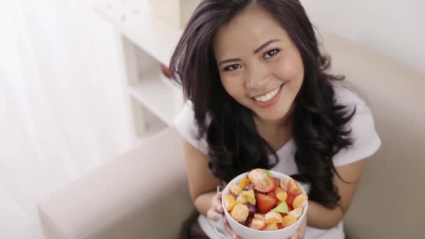 Žena s miskou ovocného salátu a ukazující palec nahoru — Stock video