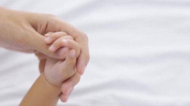 Anne ve bebek el ele tutuşuyorlar.