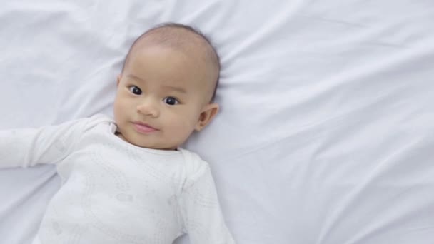 Happy baby laying on a bed — Stock Video