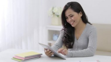 Tablet bilgisayar kullanarak evde öğrenim gören mutlu öğrenci