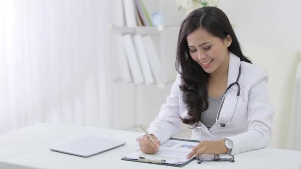 Porträt einer Ärztin auf ihrem Schreibtisch — Stockvideo