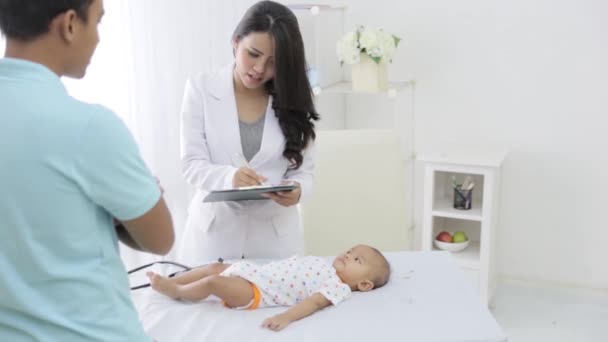 Doktor steteskop kullanarak bebeğin kalp atışlarını dinliyor. — Stok video