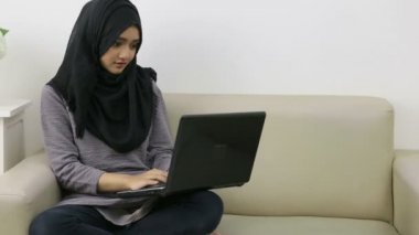 Başında dizüstü bilgisayar olan çekici genç bir kadın.