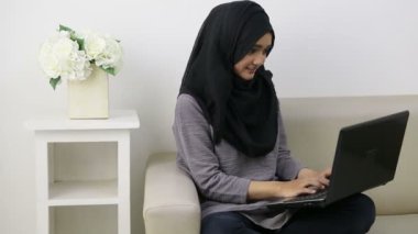 Başında dizüstü bilgisayar olan çekici genç bir kadın.