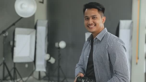 Młody człowiek fotograf uśmiechnięty — Wideo stockowe
