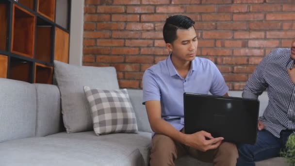Två unga casual hane diskutera med hjälp av laptop — Stockvideo
