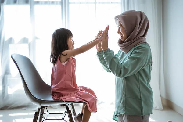 Muçulmano mãe highfive com filha — Fotografia de Stock