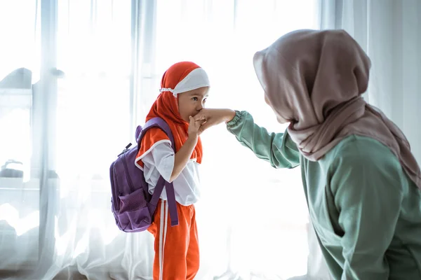 イスラム教徒の娘は学校に行く前に握手して母親にキスをする — ストック写真