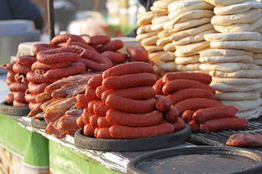 Ev yapımı çiğ sosis ve pişmiş ekmek - purlenka yığını. Çiğ sosis ve ekmek ızgara için hazırlanmış. Fast food dışında. Düz ekmek purlenka. 
