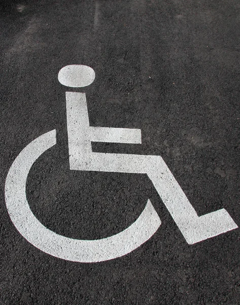 Handicap icon. Parking lot with handicap sign and symbol. Empty handicapped reserved parking space with wheelchair symbol. Disabled person sign. Copy space