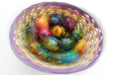 Paskalya yumurtaları. Fotoğraf çekim sırasında hareket efektler. İşlem sonrası değil. El yapımı boyalı yumurtalar sepette beyaz arka plan üzerinde izole Paskalya kutlamaları için. Paskalya. Renkli Paskalya yumurtaları.