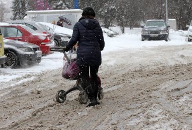 Sofya, Bulgaristan Şubat şehirde kar fırtınası sırasında insanlar yürüyüş çok karlı kaldırım ve yol 26,2018. İnsanlar adım buzlu bir yolu üzerinde buzlu kaldırım. Kaplarda karda caddeler ve yollar.