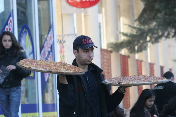 ピザの配達人はペルニク ブルガリアの通りに手にピザを持って来る 2008 — ストック写真
