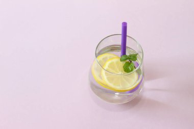 Bir bardak su, limon ve nane. Bir bardak saf su ve taze organik limon ve nane mor arka plan üzerinde izole. Detoks ve sağlıklı gıda kavramı